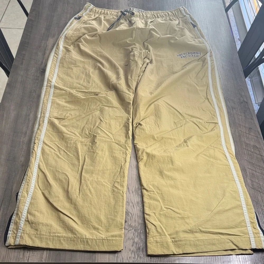 Vintage 90’s  Y2K Abercrombie and Fitch tan track pants with white stripes.